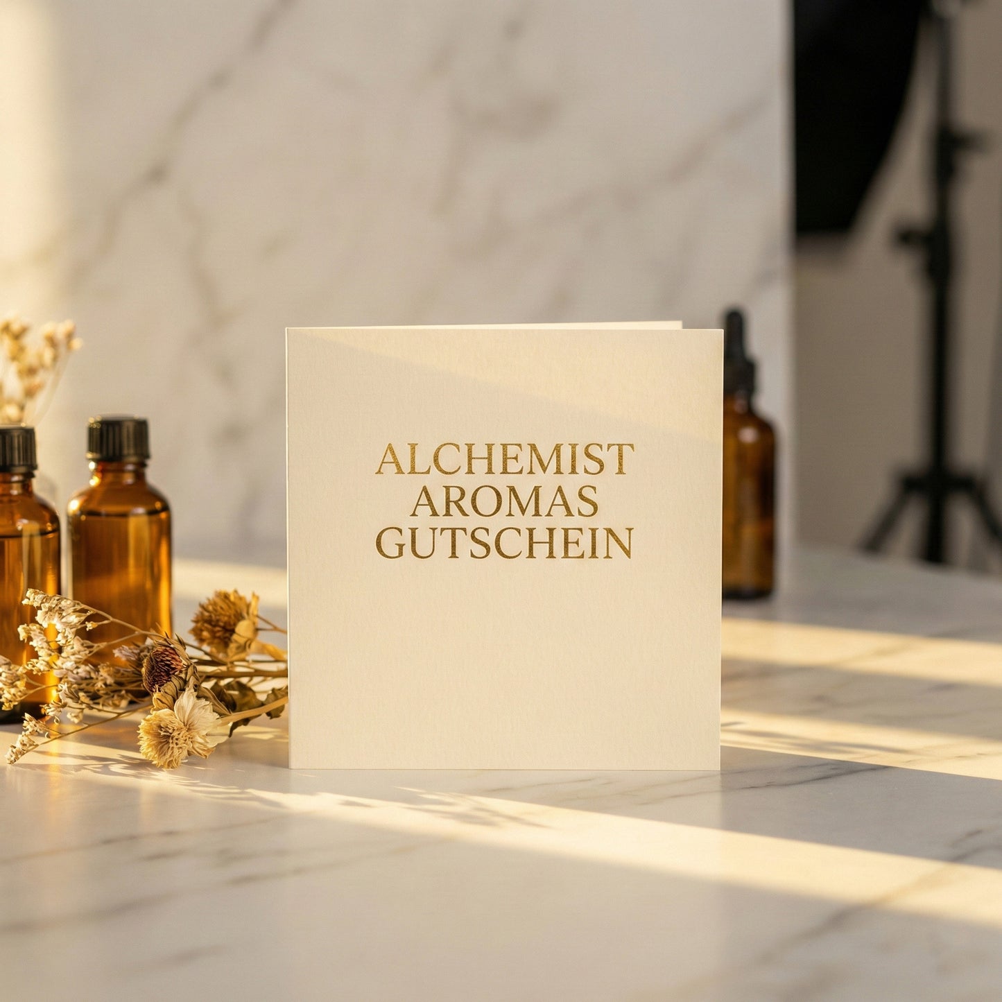 Alchemist Aromas perfume gift voucher displayed on a marble surface with floral accents
