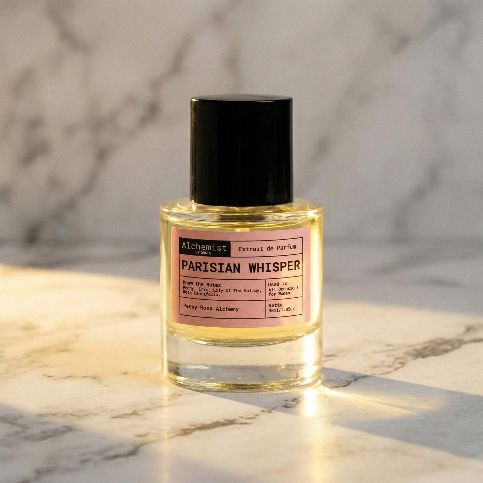 Alchemist Aromas Parisian Whisper Extrait de Parfum in a glass bottle with a black cap on marble background